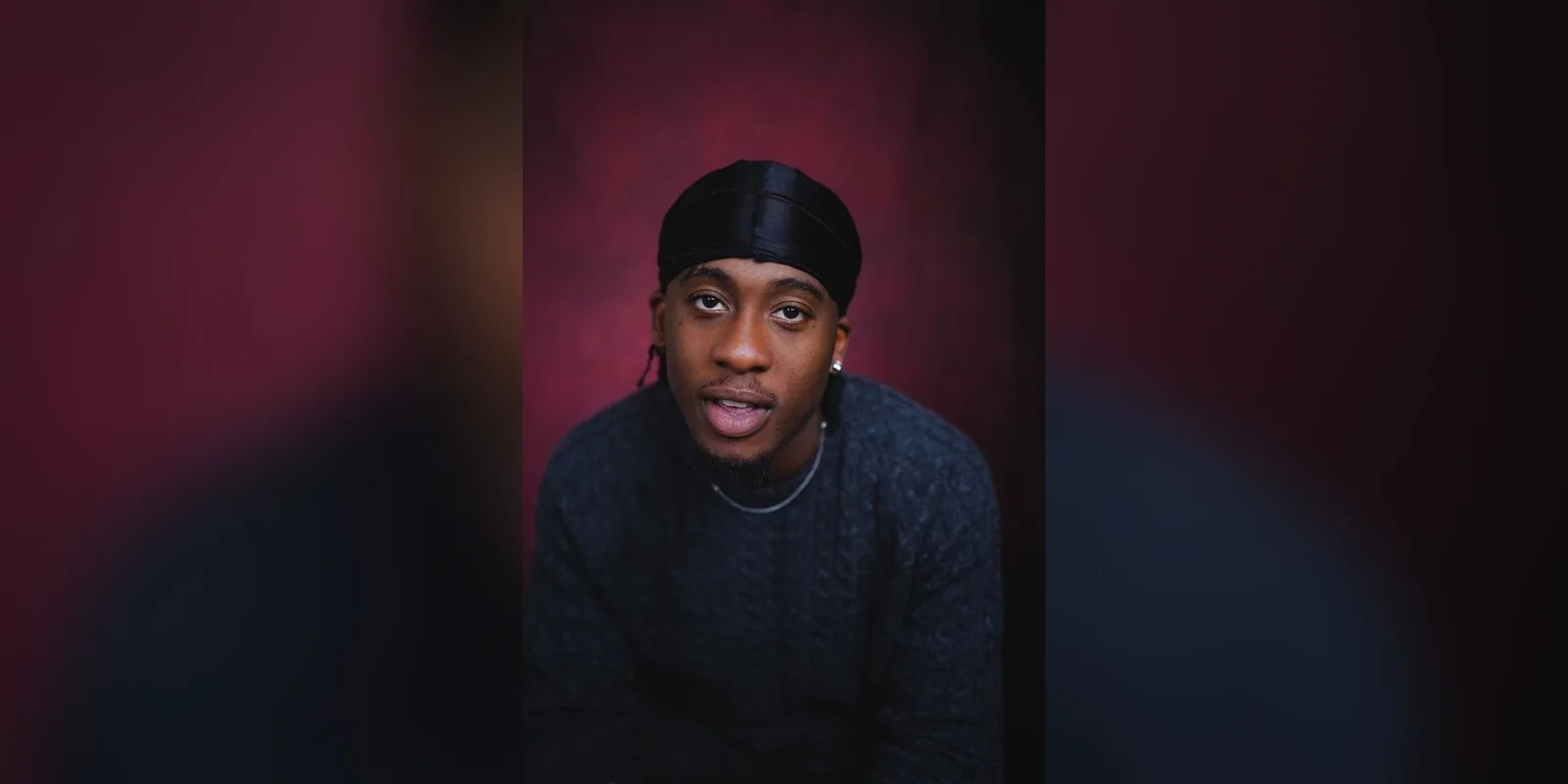 Headshot of actor Kayode Shoboyede in a dark jumper and durag