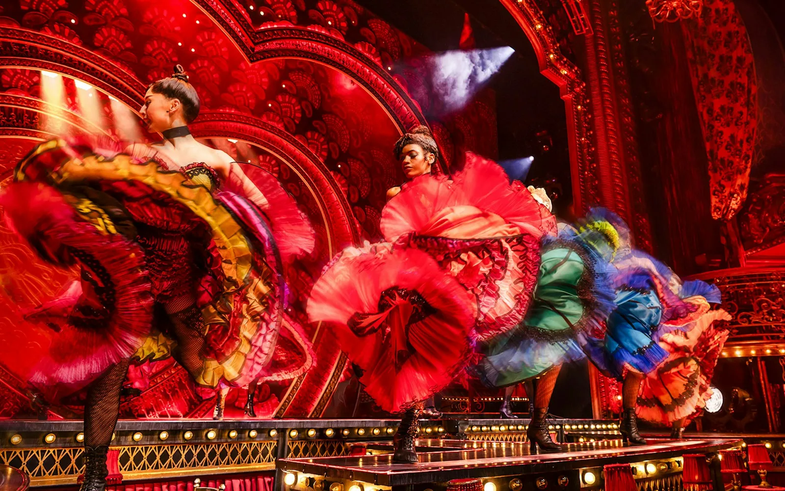 Dancers in vivid red, green and blue frilled skirts kick across the stage of Moulin Rouge! The Musical