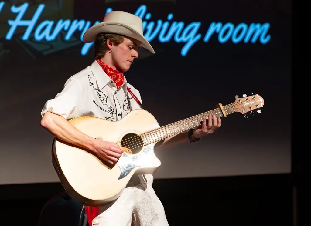 Samuel Heller as Danny Rogers performing with acoustic guitar in Under the Mersey Moon